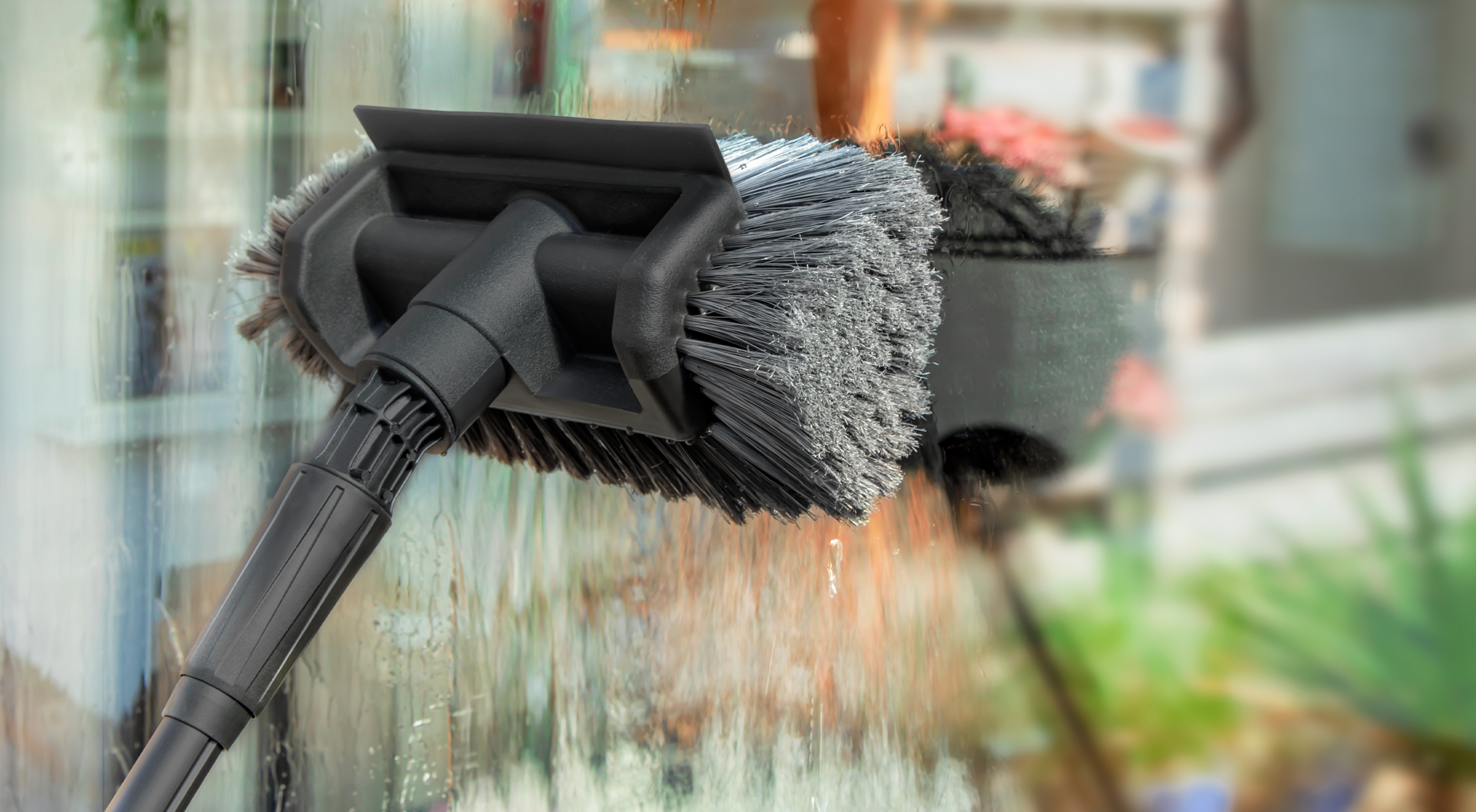 Limpiar ventanas con un cepillo de lavado VONROC.